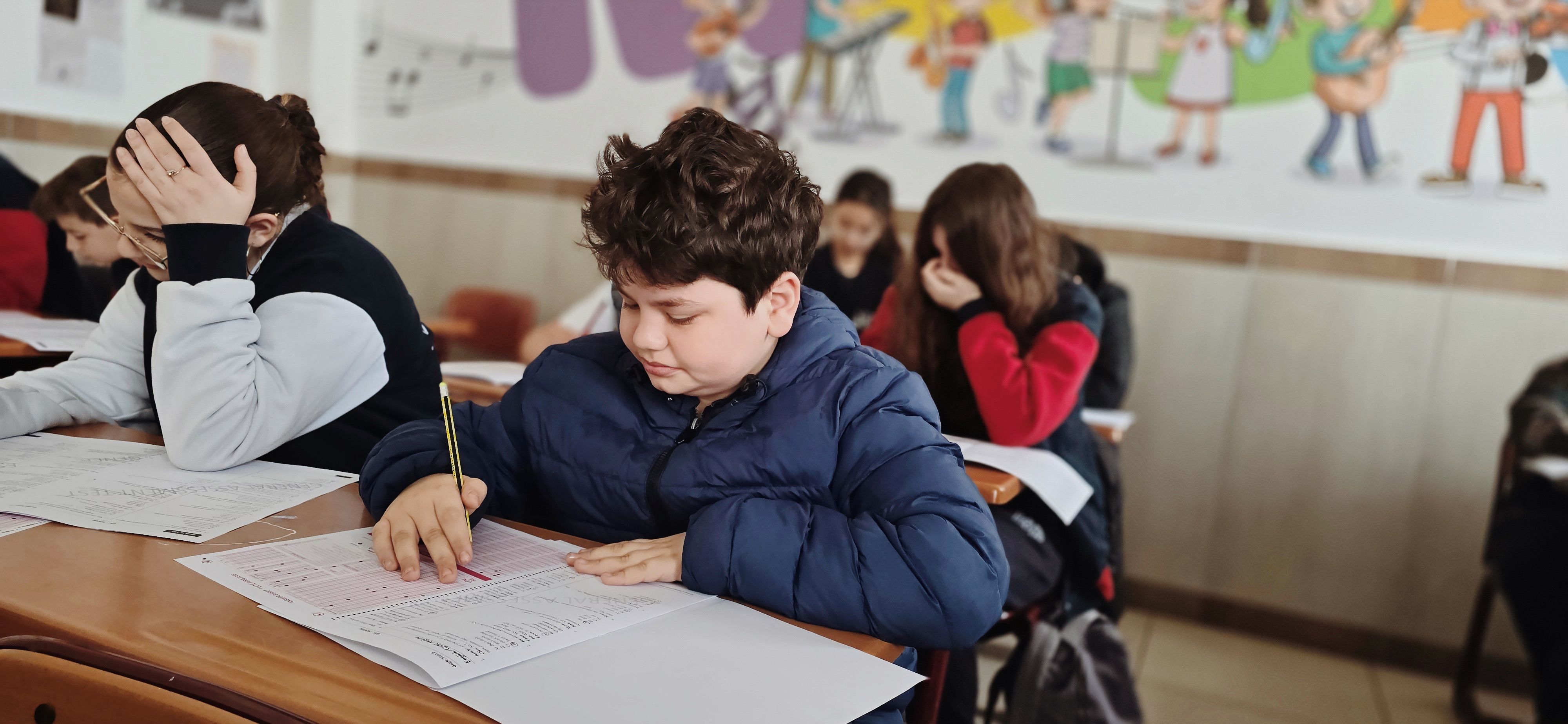 Students focused while taking a written test in a classroom, highlighting academic honesty concerns